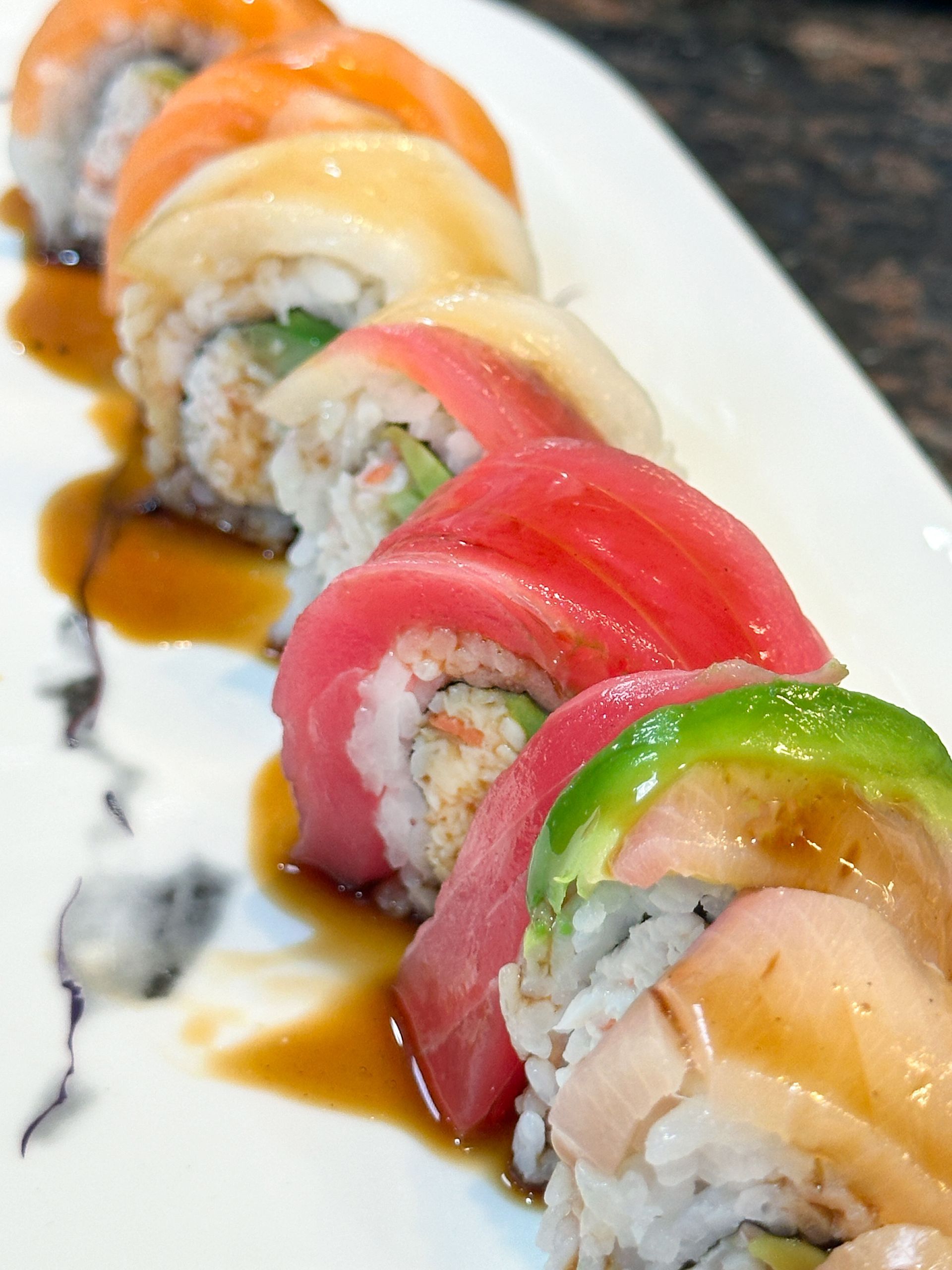 A close up of a sushi roll on a white plate.