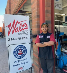 A man stands in front of a walt 's auto service sign | Walt's Auto Service