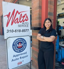 A woman is standing in front of a walt 's auto service sign | Walt's Auto Service