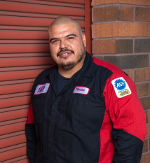 A man wearing a black and red jacket with the word ase on the sleeve | Walt's Auto Service