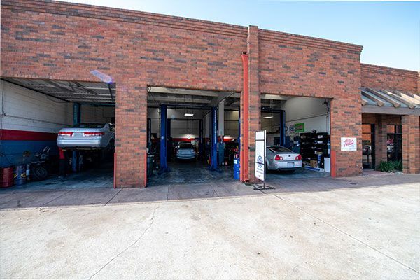 A brick building with cars parked inside of it. | Walt's Auto Service