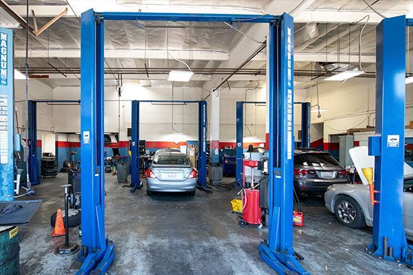 A garage with a lot of cars on lifts. | Walt's Auto Service