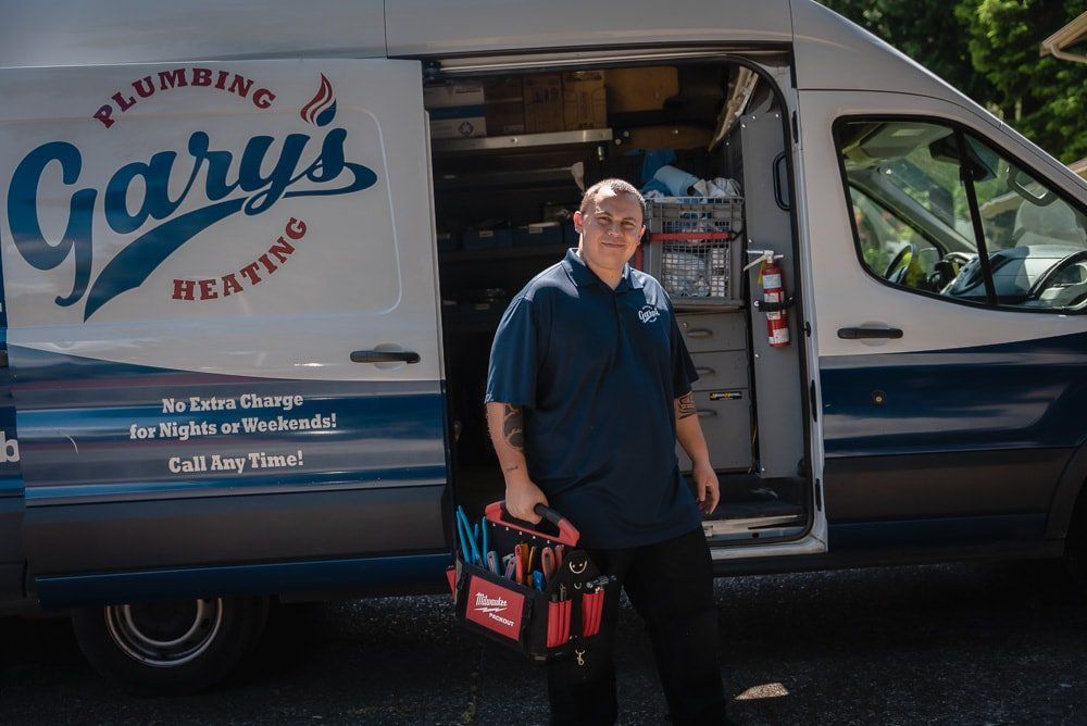 A man is standing in front of a plumbing and heating van.