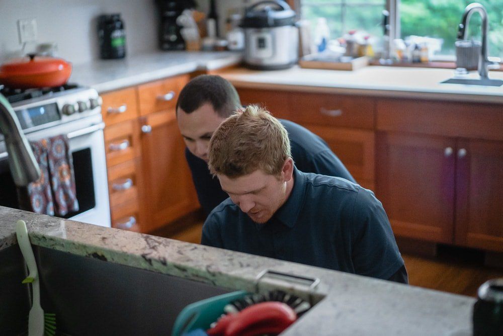 Photo of plumbers installing a garbage disposal