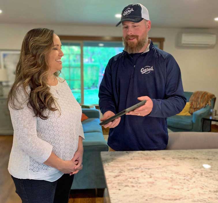A man and a woman are standing next to each other in a living room.