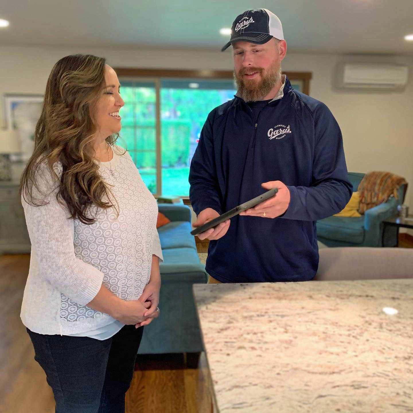 A man and a woman are standing next to each other in a living room.