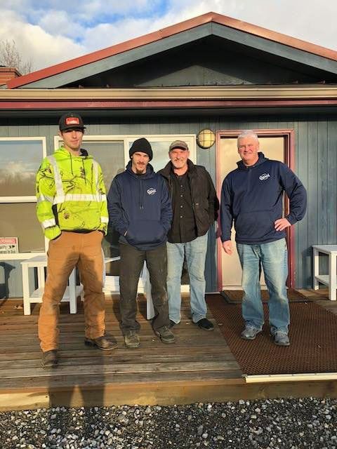 A group of men are standing in front of a house.