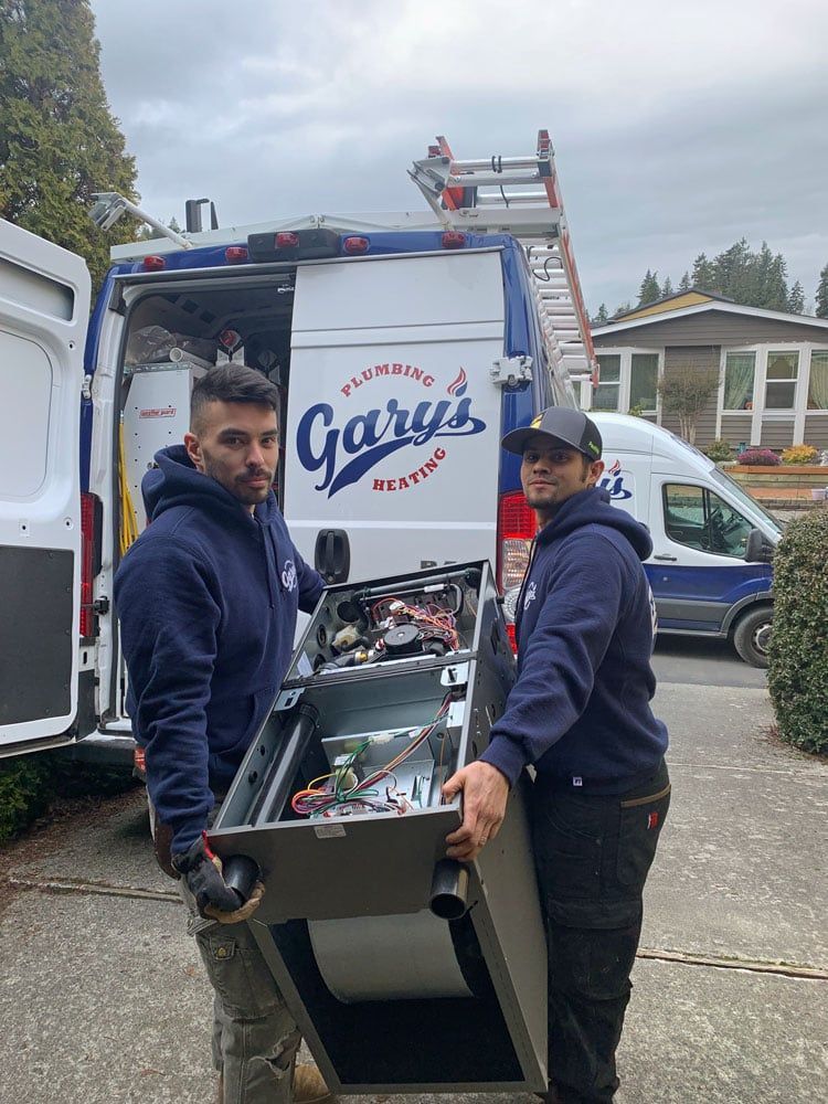 Two men are carrying a piece of equipment out of a van.