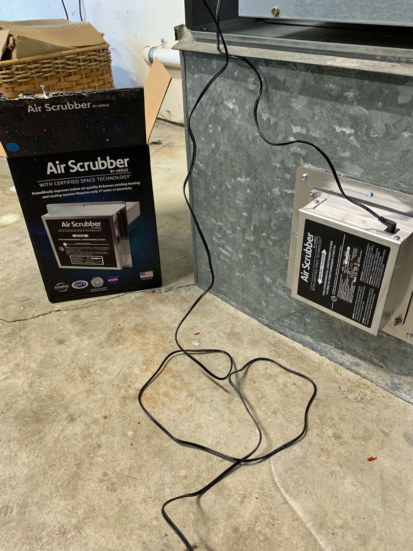 An air scrubber is sitting on the floor next to a box.