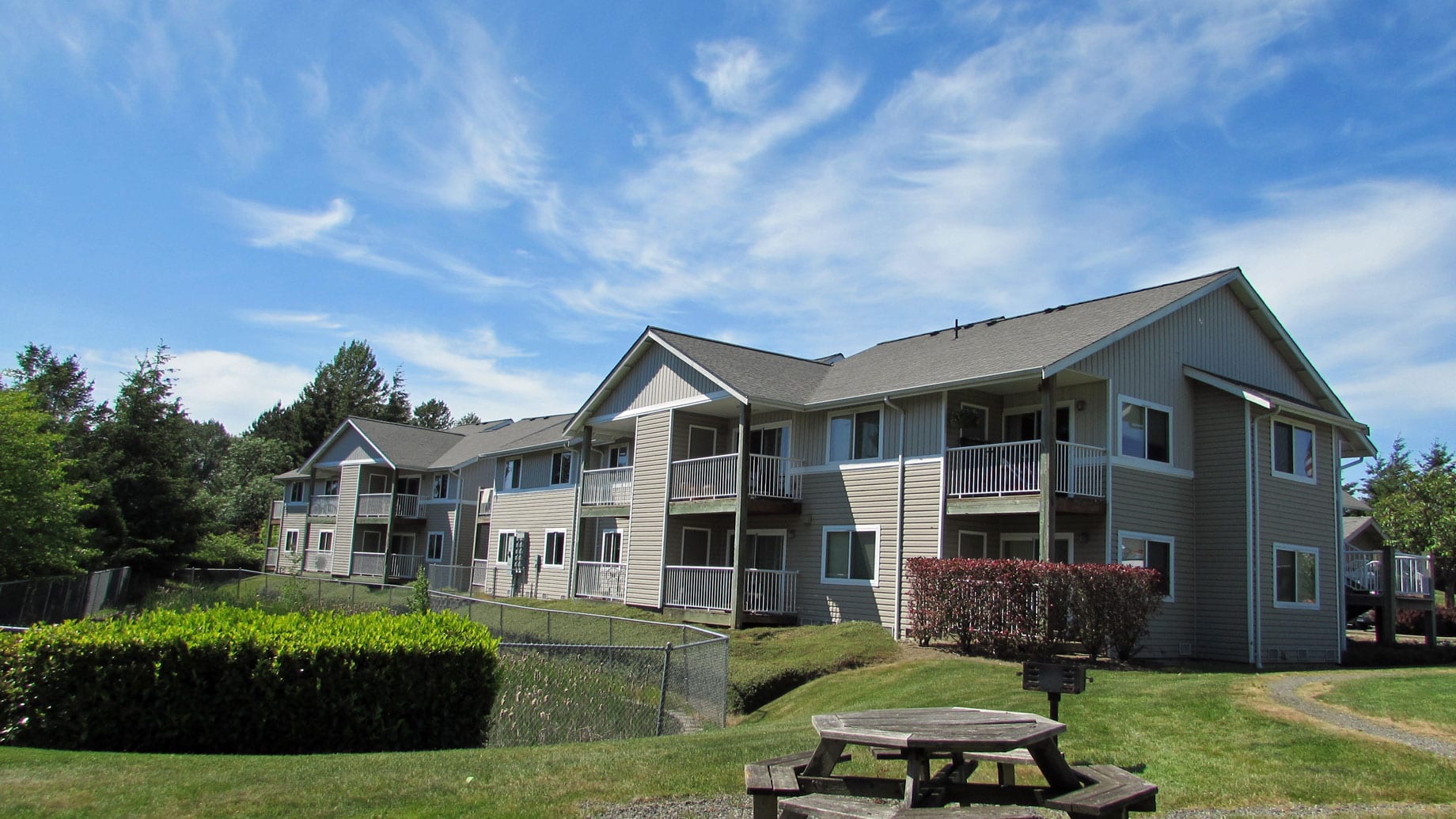 A large apartment building with a picnic table in front of it