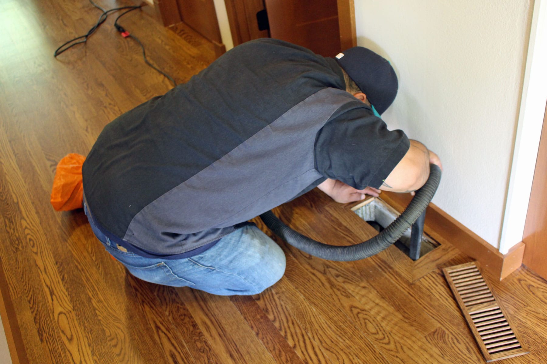 Photo of a plumber cleaning an air duct