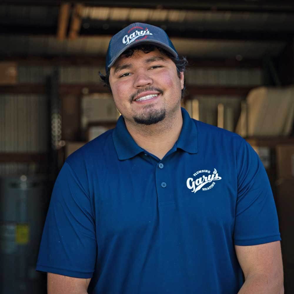 A man wearing a blue polo shirt and a hat is smiling for the camera.