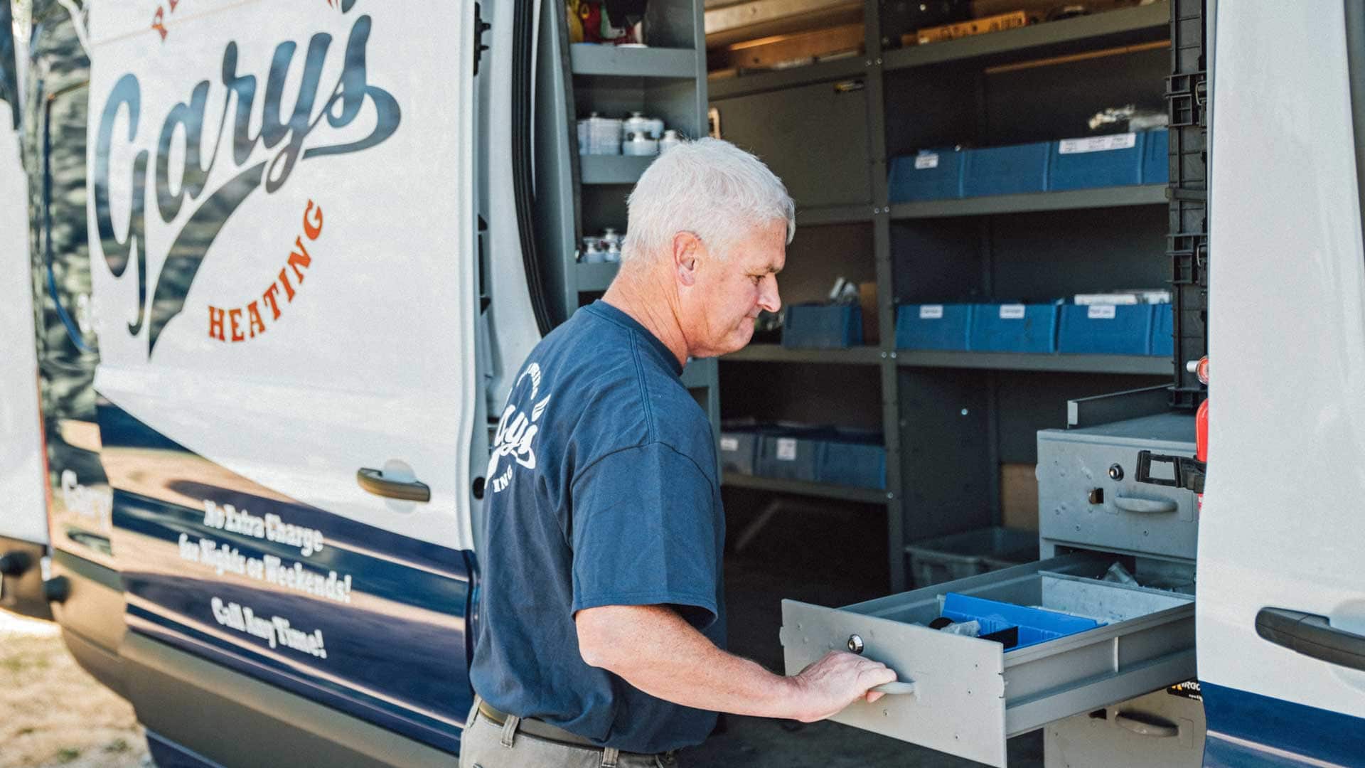A man is opening a drawer in a van.