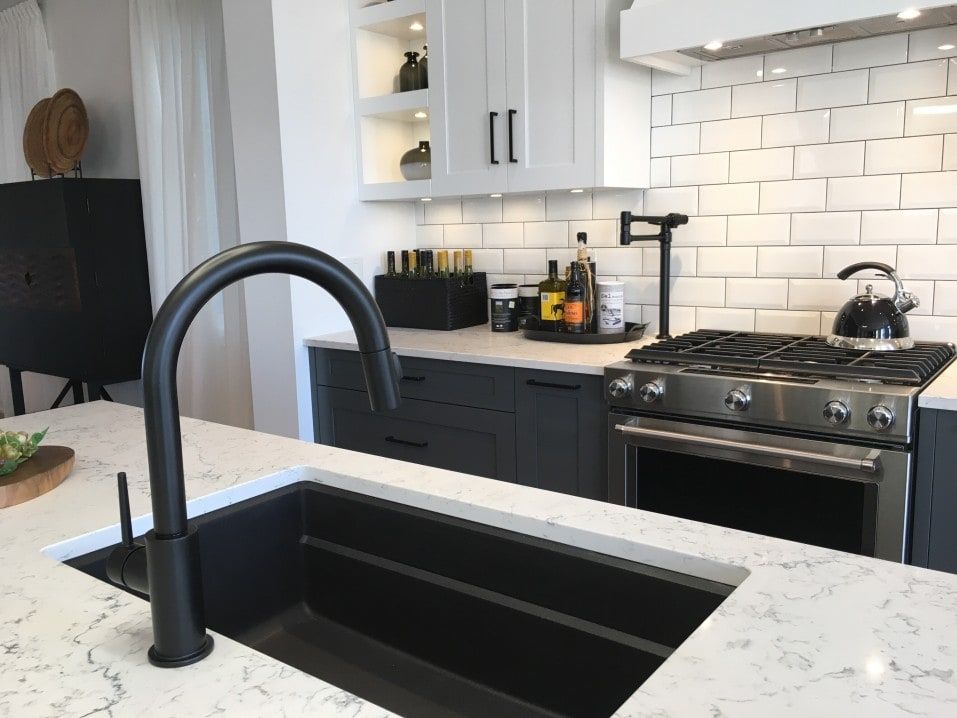 A kitchen with a black sink and a stove
