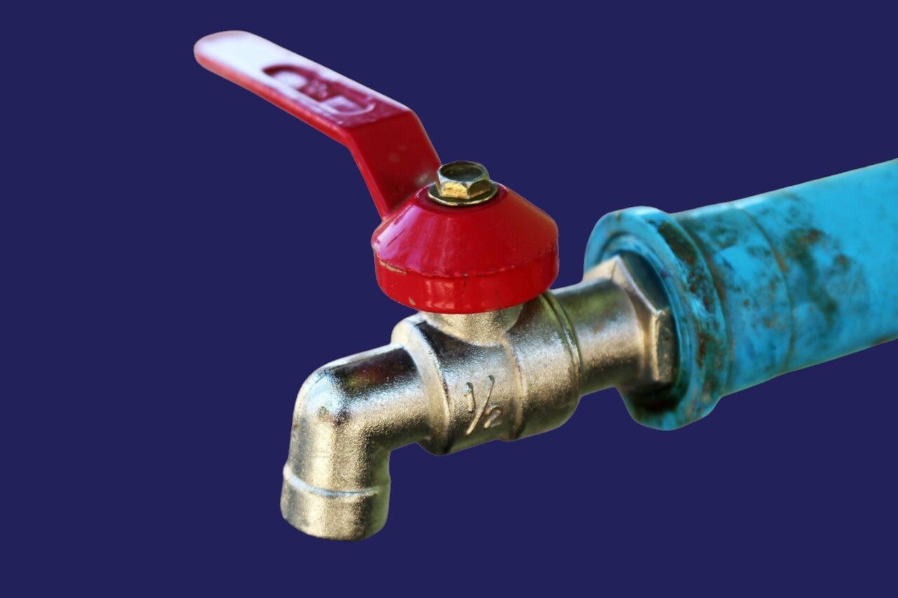 A close up of a faucet with a red handle
