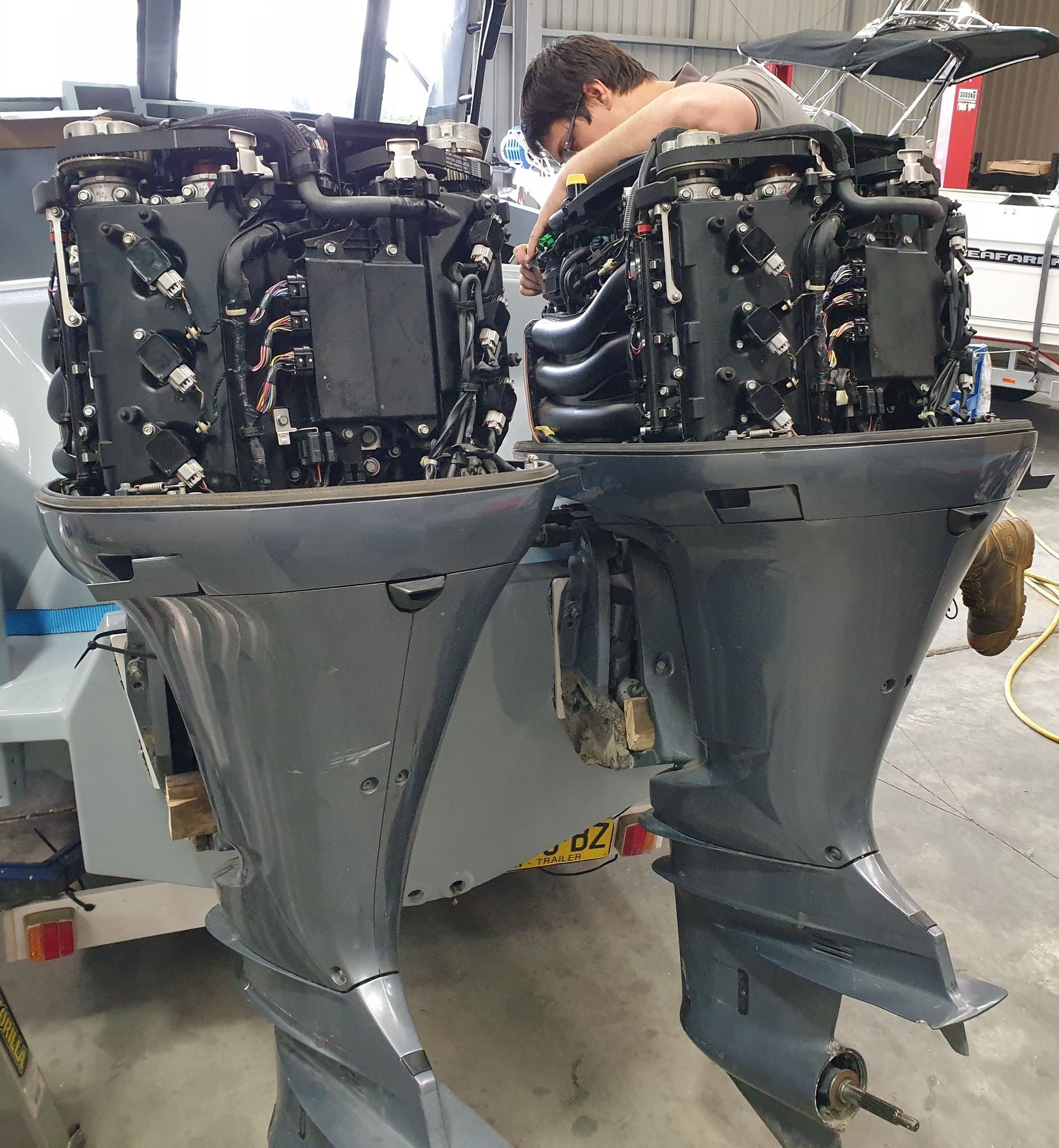 a man repairing two outboard engines