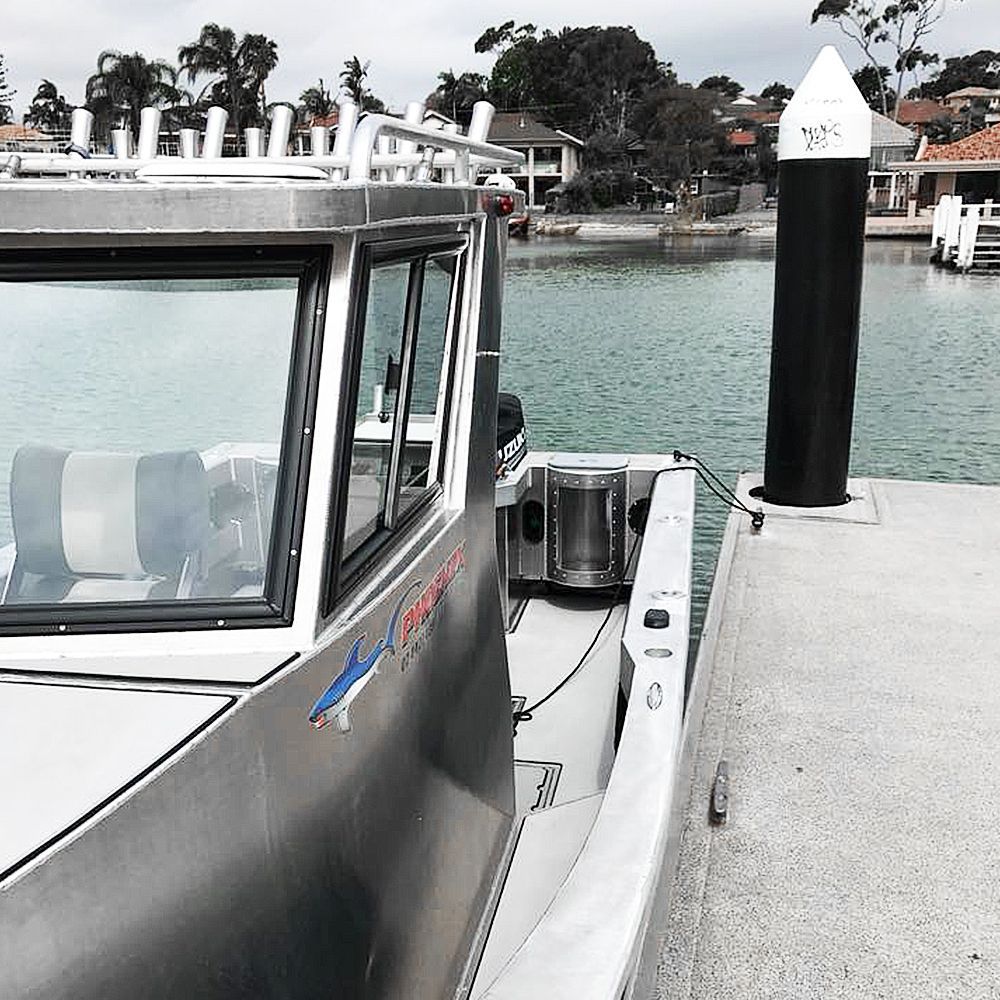 An aluminium boat from Phoenix Boats is docked at a dock in the water