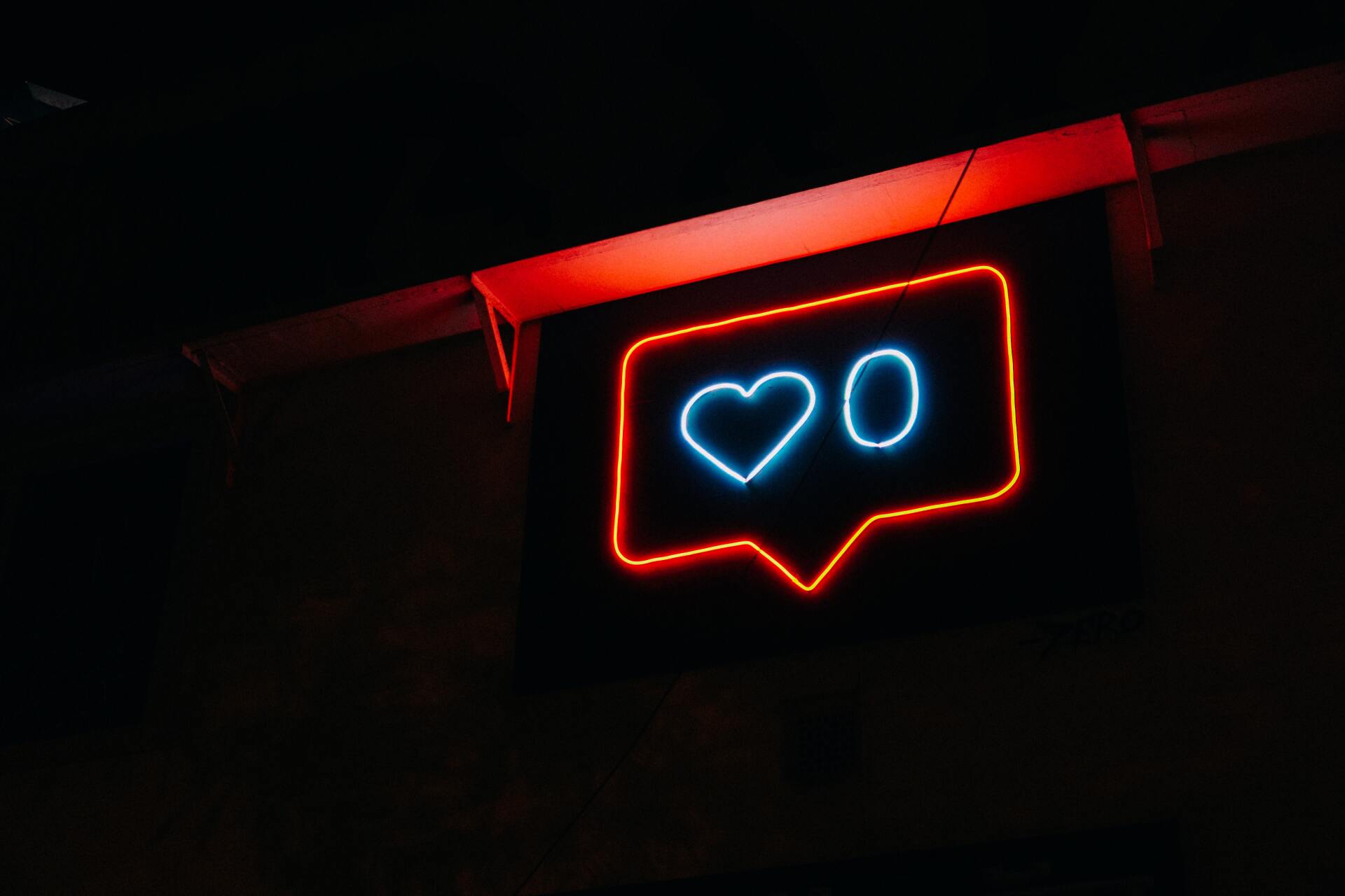 a neon sign with a heart in a speech bubble .