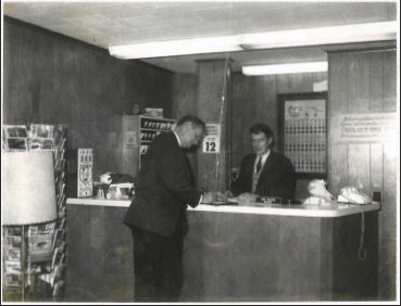 historical picture of a guest signing in at the front desk