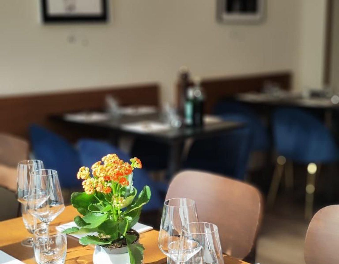 Un vaso di fiori è appoggiato su un tavolo in un ristorante.