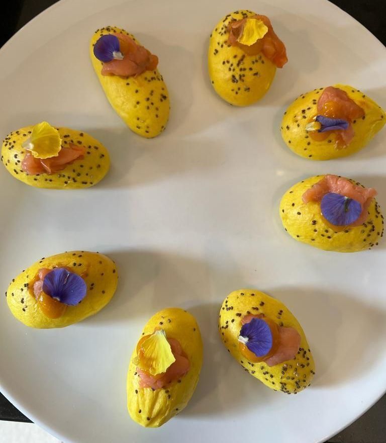 Un piatto bianco con patate gialle e fiori