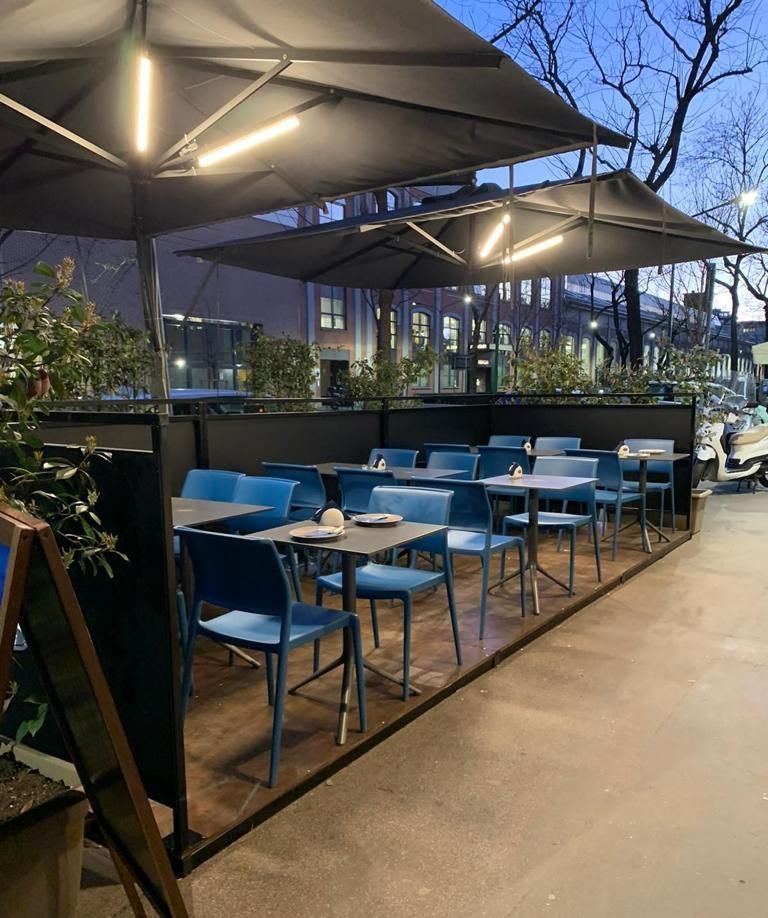 Un ristorante con tavoli e sedie sotto gli ombrelloni