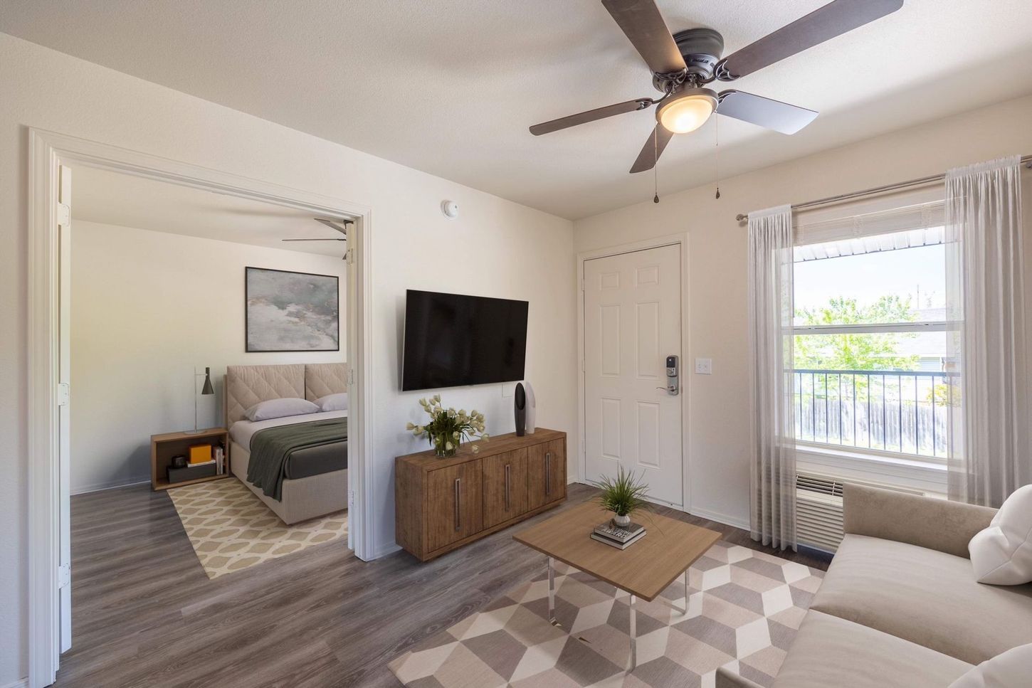 A living room with a ceiling fan and a flat screen tv.