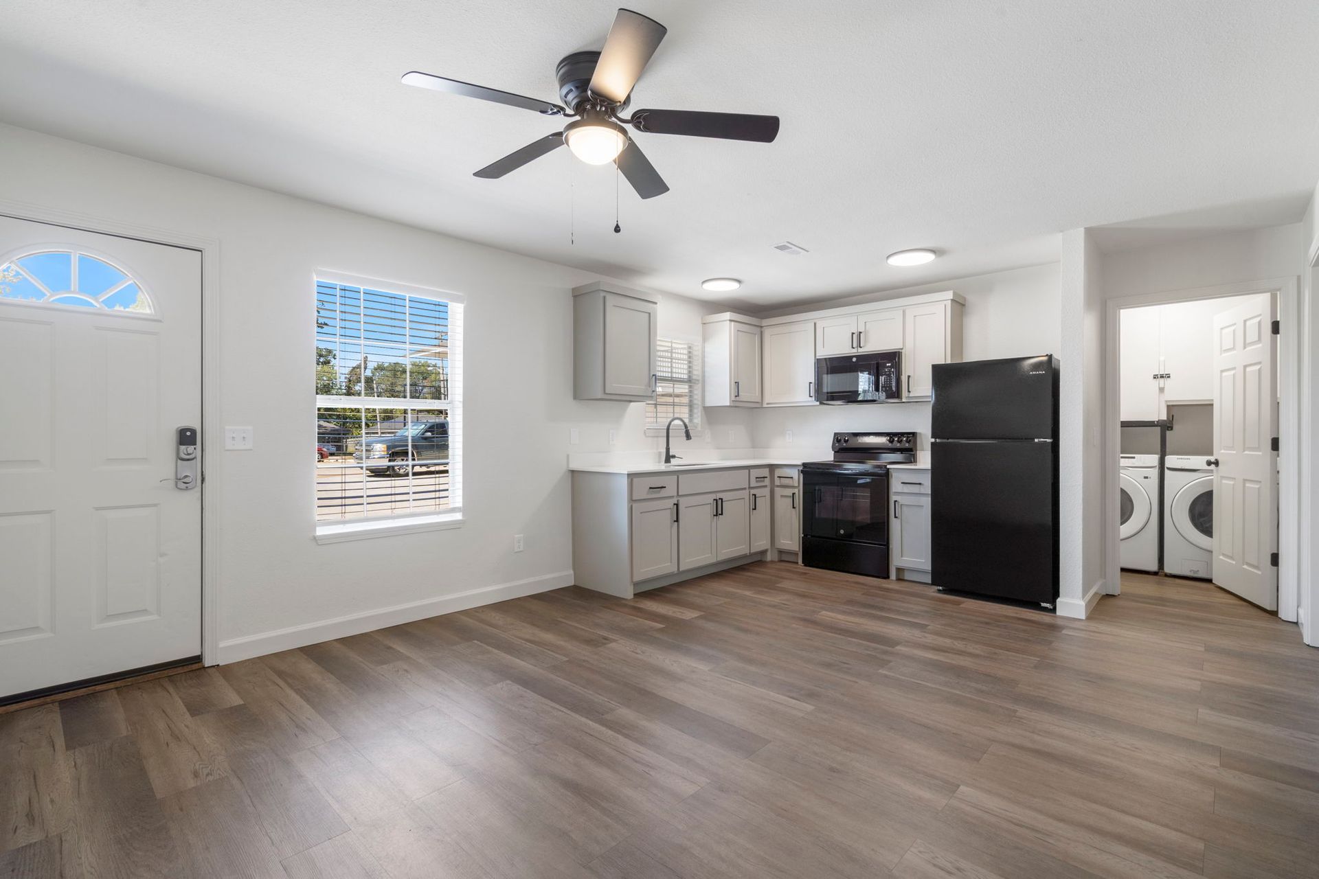 There is a ceiling fan in the living room and a kitchen.