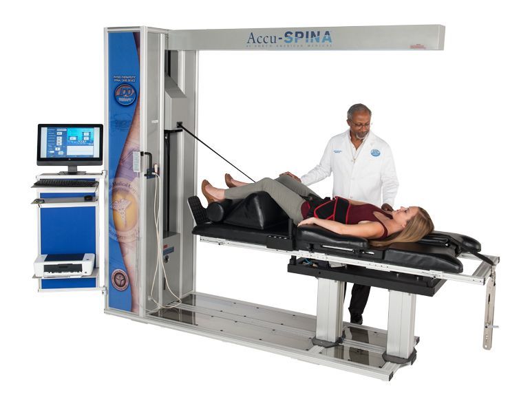 Medical imaging machine scanning a patient lying on a table, with a technician and control monitor nearby