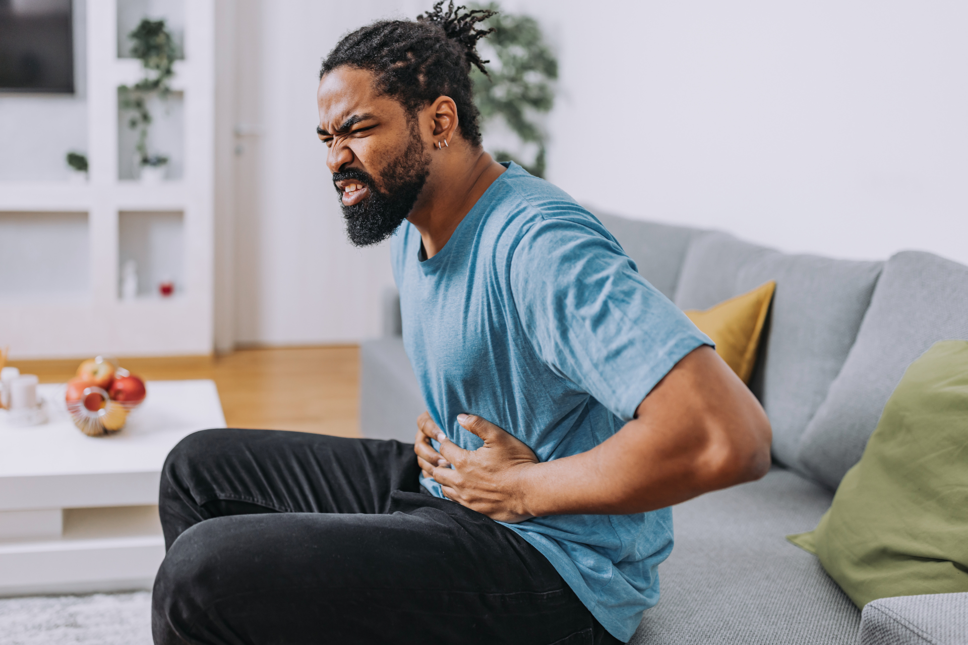 Silhouette of a person jumping with arms raised against a sunset.