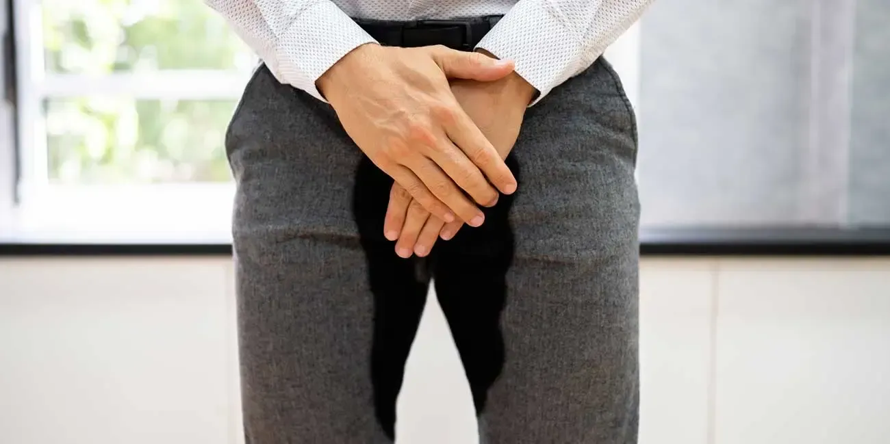 Couple running on a path in a park; woman in orange, man in blue, trees in background.