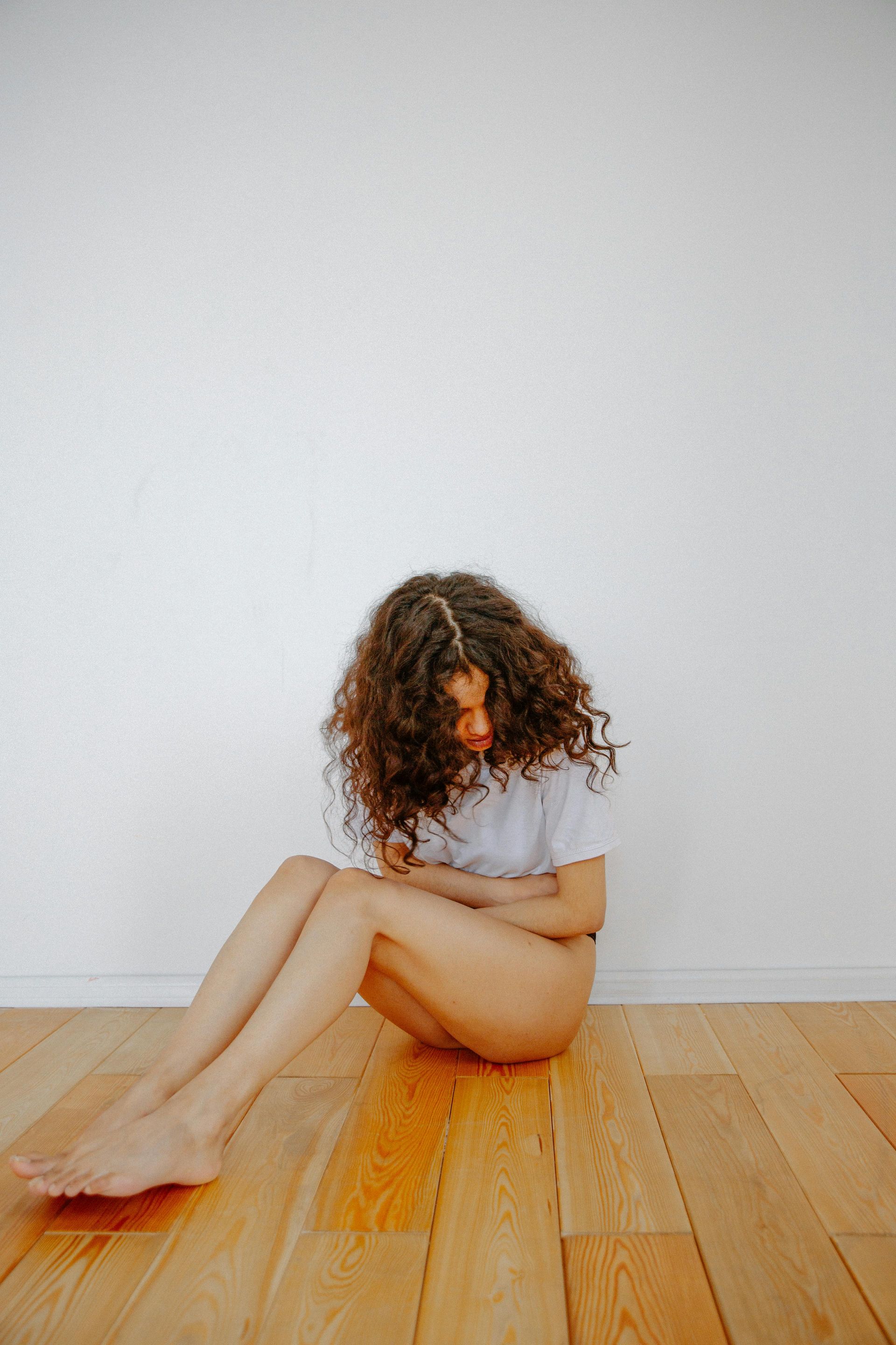 Couple running on a path in a park; woman in orange, man in blue, trees in background.