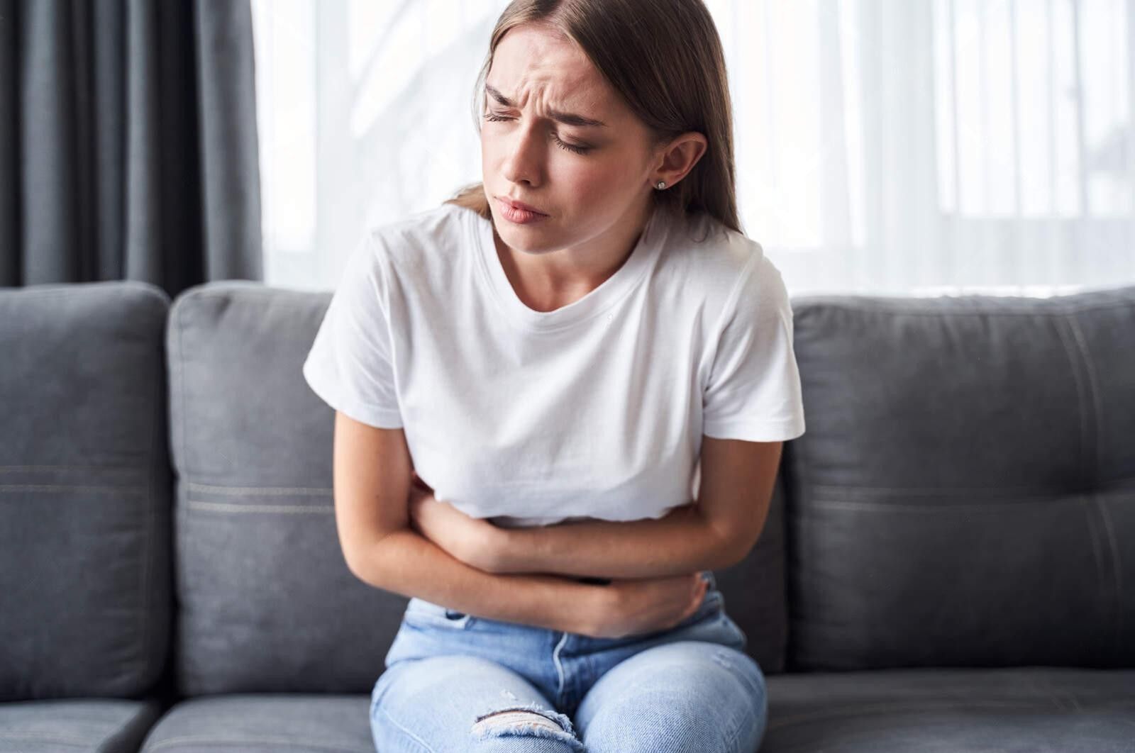Man kissing a woman's forehead while hugging her in a field of yellow flowers.