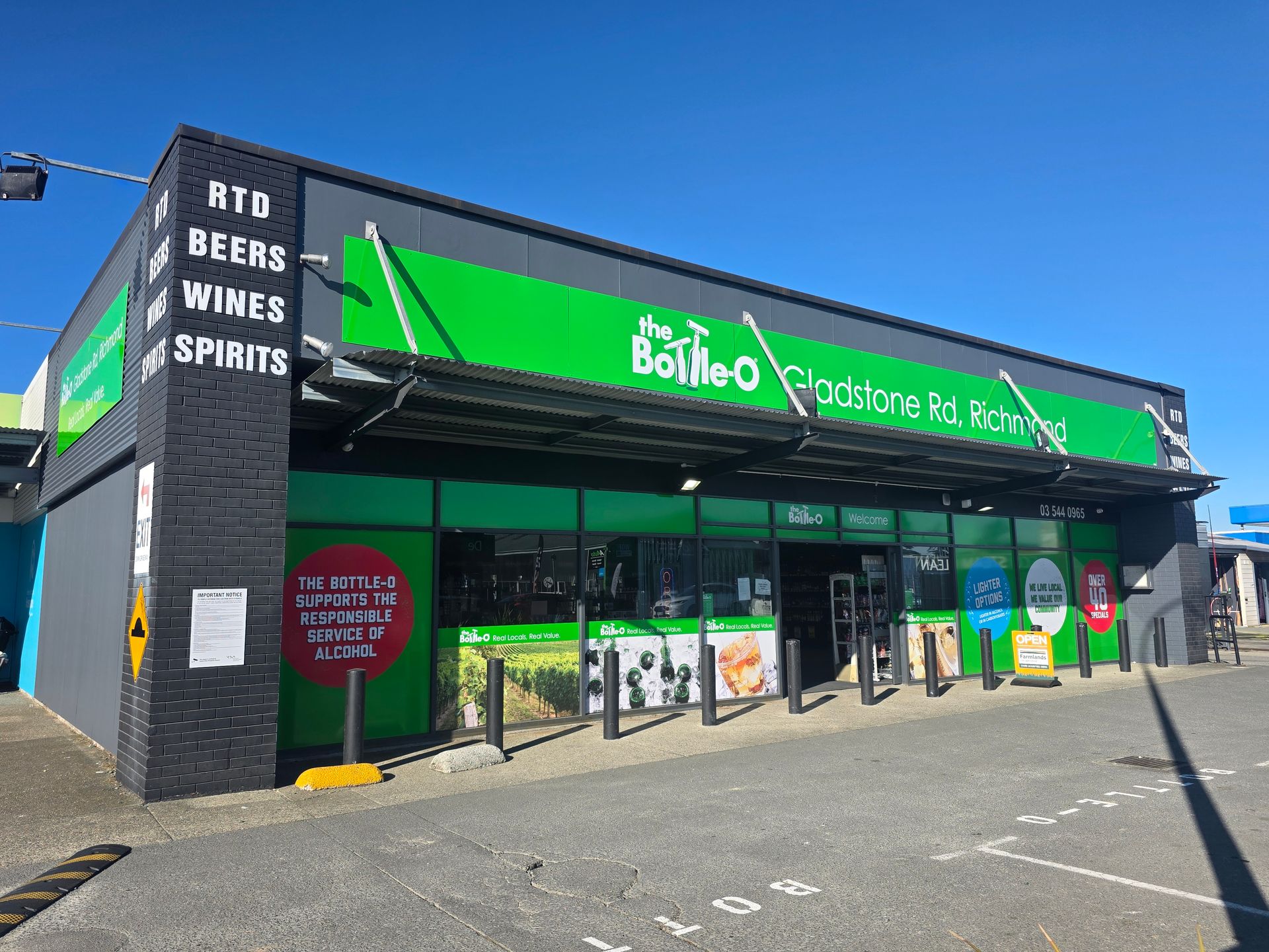 Bottle-O liquor store in Gladstone, Australia. Green and black signage, with front entrance under a green awning.