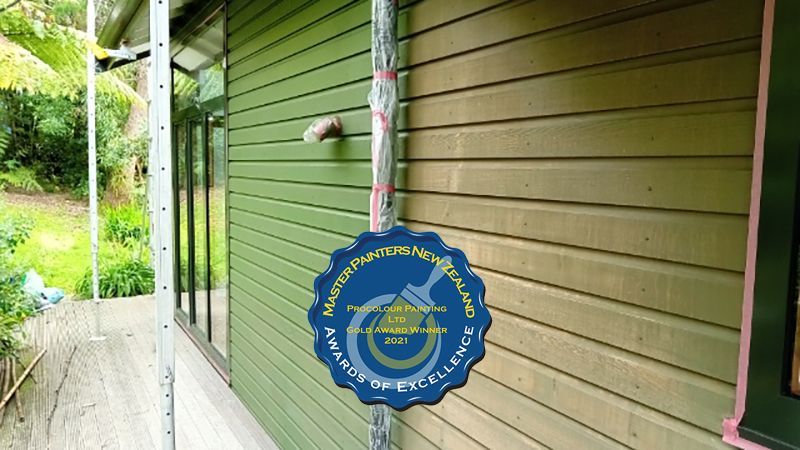 Green house exterior with awards sticker for professional painting.