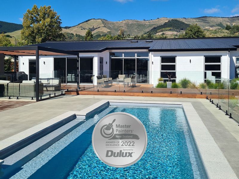 Modern white house with pool, patio, and mountain view, awarded Master Painters 2022 by Dulux.