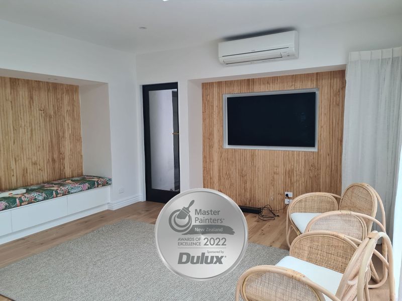 Living room with wood paneling, TV, chairs, and a 