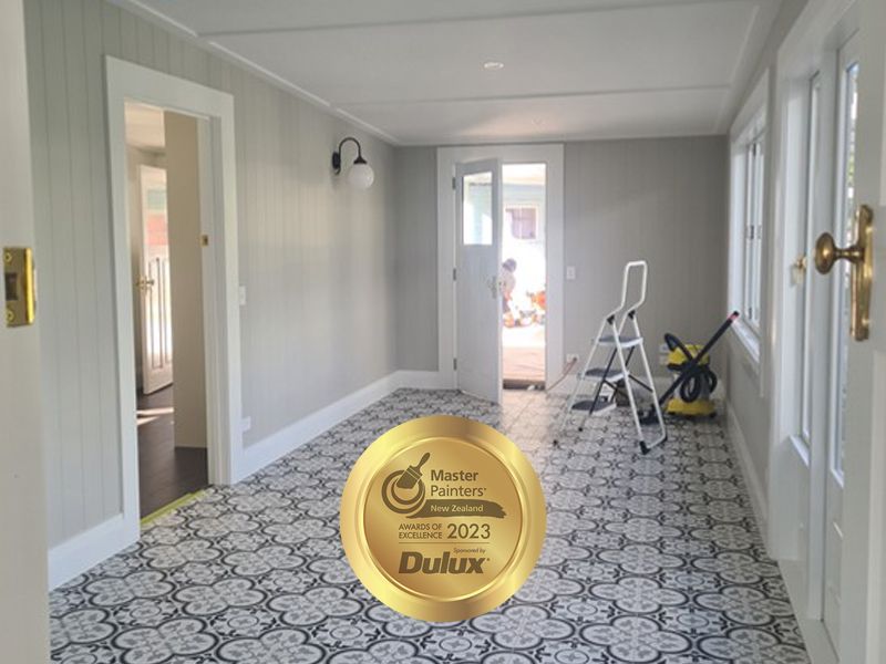 Interior room with light gray walls, patterned floor, doors, and a Dulux Master Painter award.