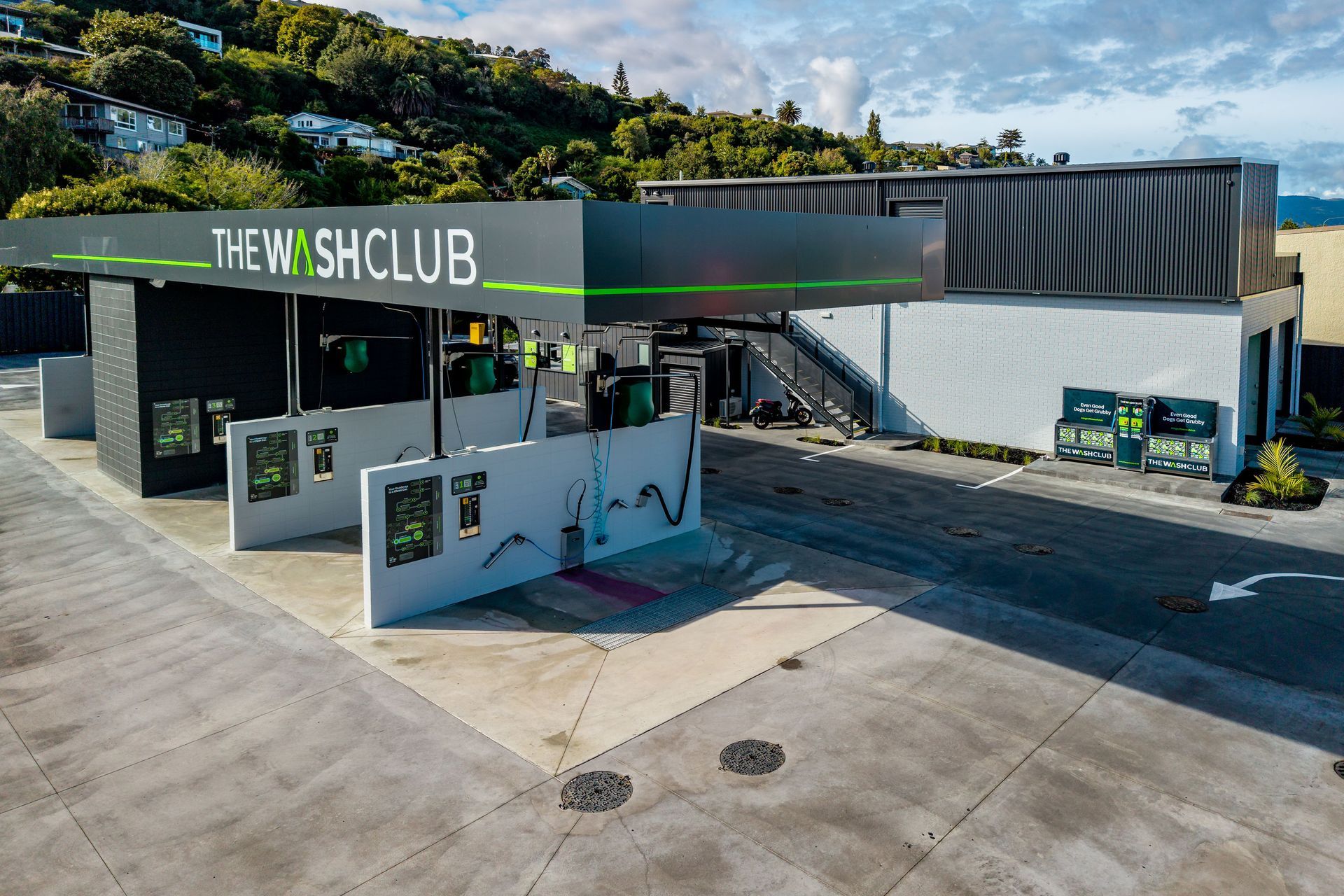 A car wash facility with a black and green sign,