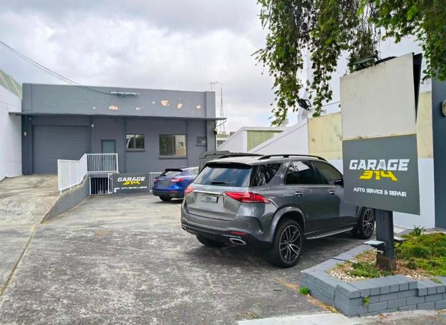 A car is parked in front of a garage.