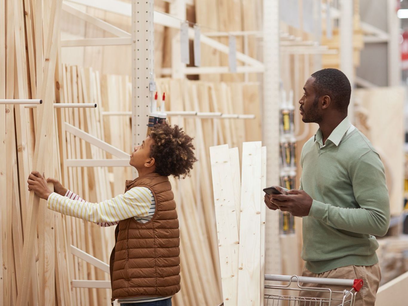 father and son shopping for lumber in a store