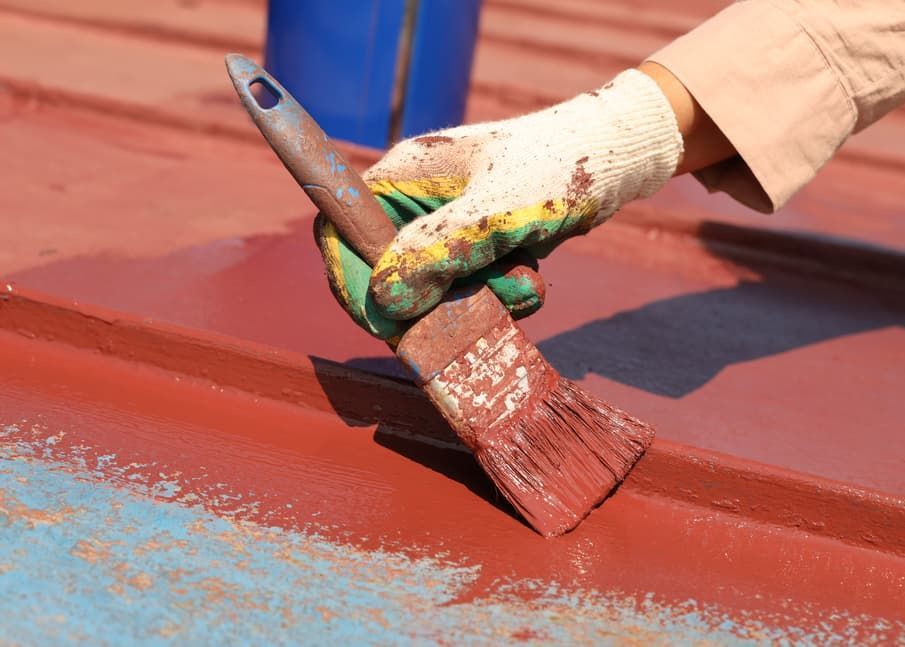 A Person Is Painting a Metal Surface with A Brush — Greg Cannon Painting In Raymond Terrace, NSW