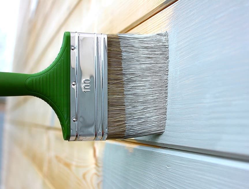 A Brush Is Being Used to Paint a Wooden Wall — Greg Cannon Painting In Raymond Terrace, NSW
