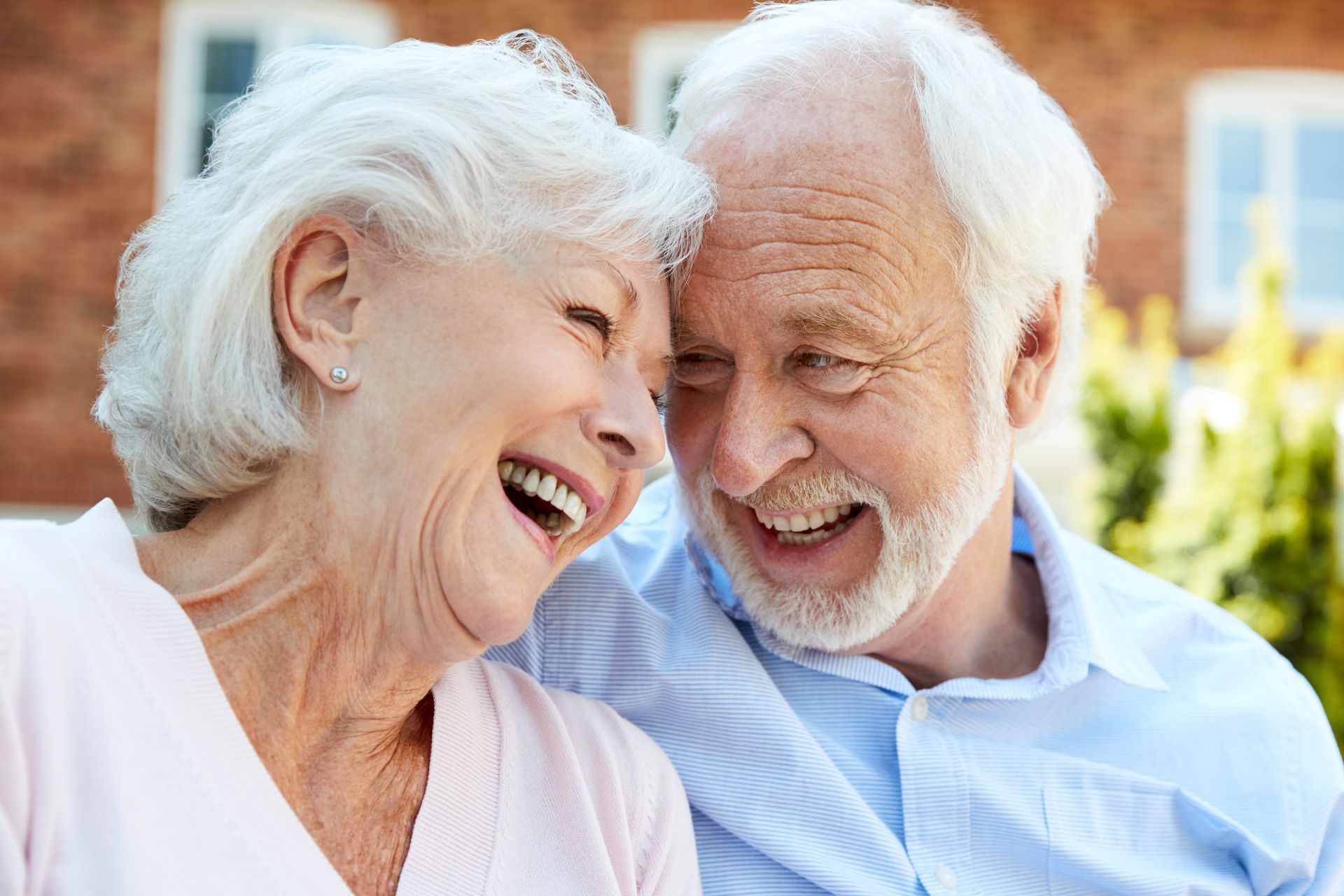 Smiling older couple embracing outdoors, laughing together