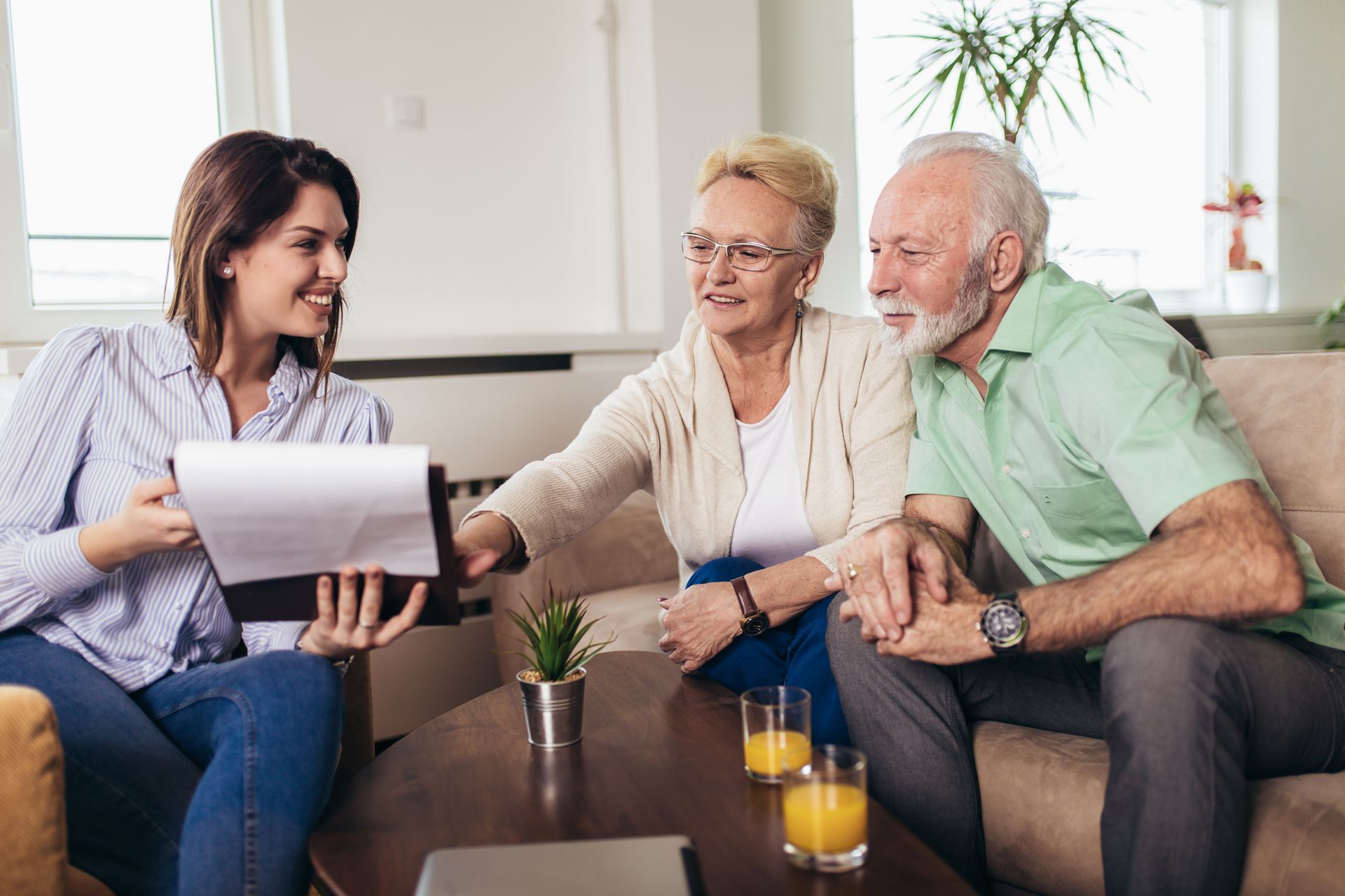 Woman showing document to a senior couple on a sofa