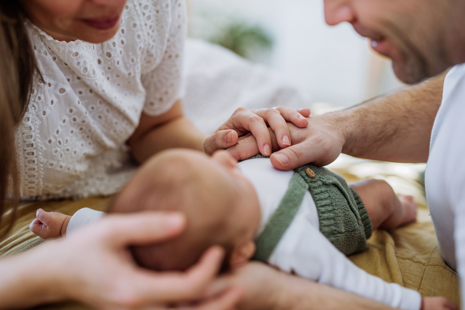 Parents gently touch their newborn baby