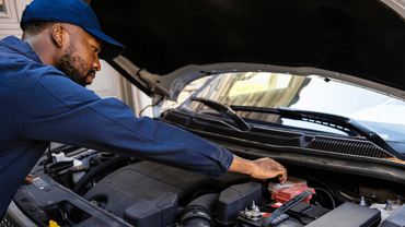 a mechanic doing an auto repair under the hood of a car