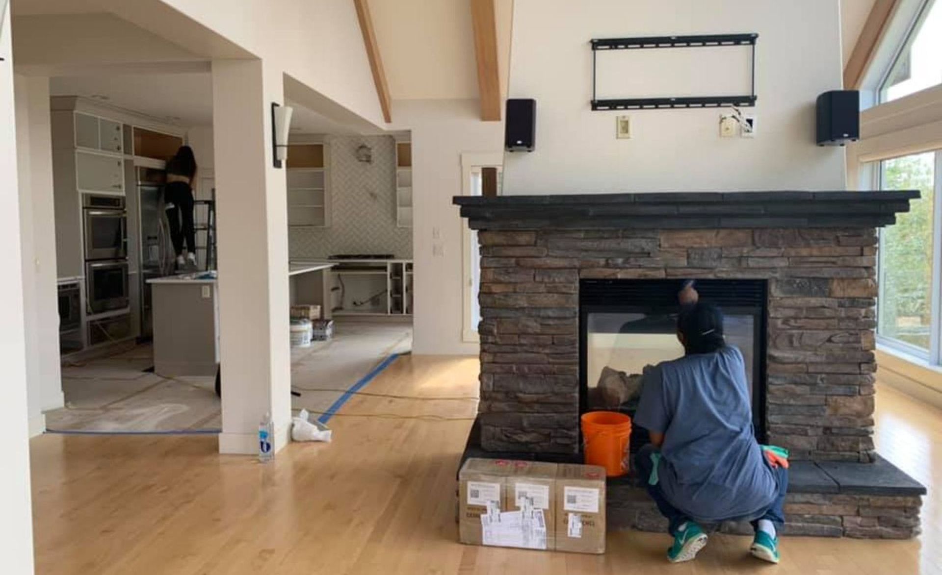 A man is cleaning a fireplace in a living room.
