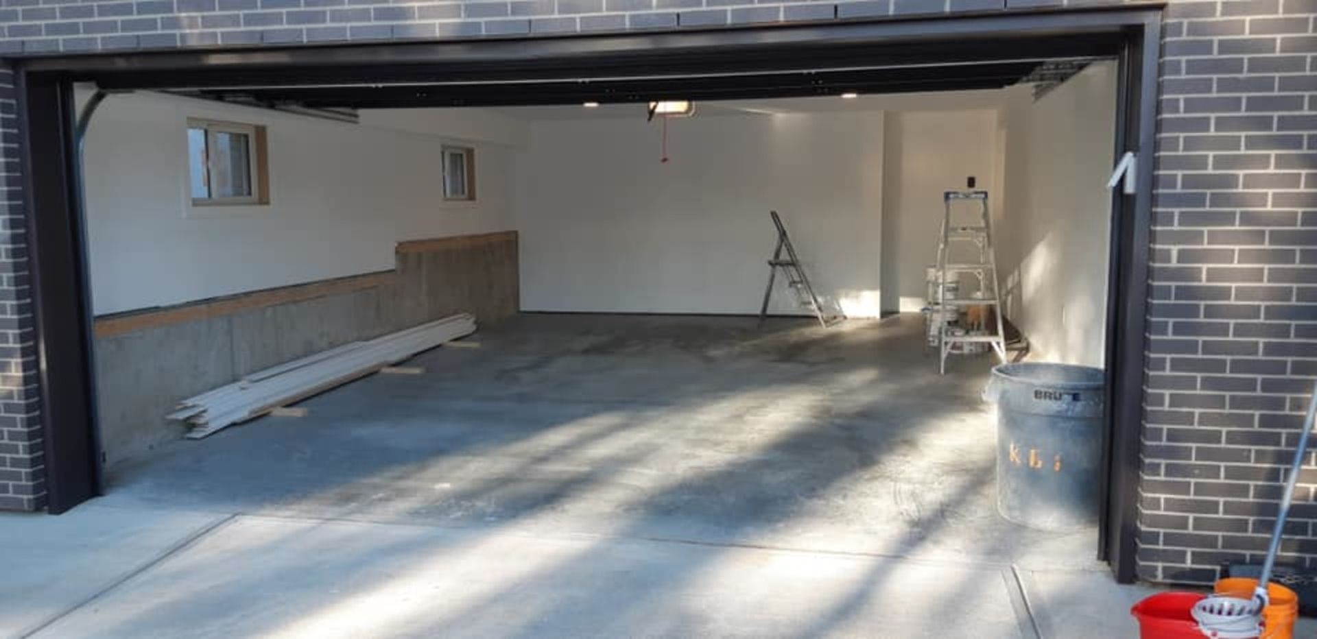 Garage post-construction cleanup in progress with visible tools and materials