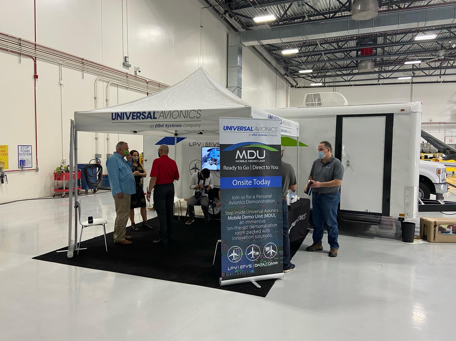 A group of people are standing around a tent in a warehouse.
